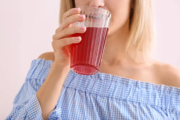 Mujer bebiendo sabroso jugo de granada sobre fondo claro, primer plano — Foto de Stock