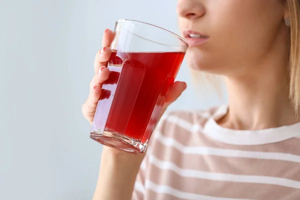 Vrouw drinken smakelijke granaatappelsap op lichte achtergrond, close-up — Stockfoto