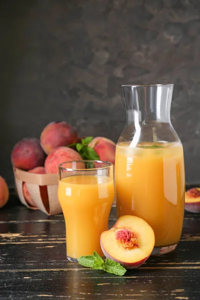 Glass and bottle of tasty peach juice on wooden table — Stock Photo, Image