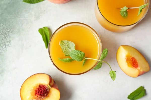 Glasses of tasty peach juice on light background — Stock Photo, Image