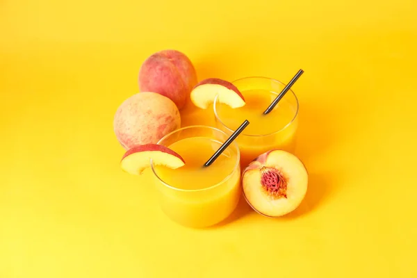 Bicchieri di succo di pesca saporito su sfondo a colori — Foto Stock