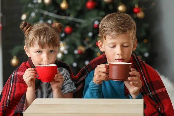 Lindos niños bebiendo chocolate caliente en casa en Nochebuena — Foto de Stock