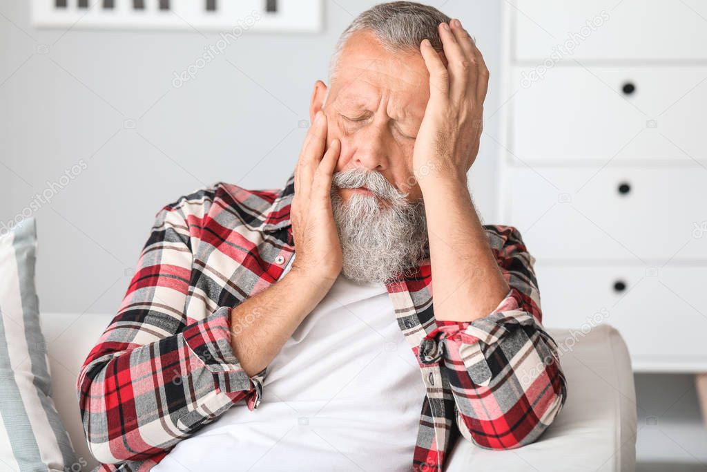 Senior man suffering from toothache at home