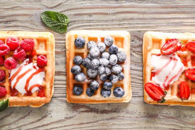 Çilek ile farklı tatlı waffle ahşap masada bir dondurma