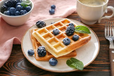 Ahşap masada lezzetli waffle ve çilek ile Plaka