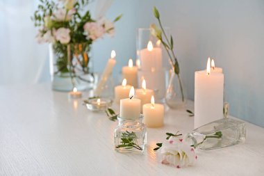 Masada güzel yanan mumlar ve çiçekler