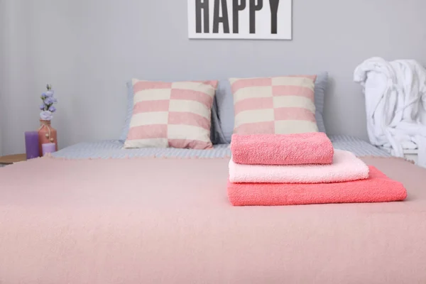 Stack of clean towels on bed — Stock Photo, Image