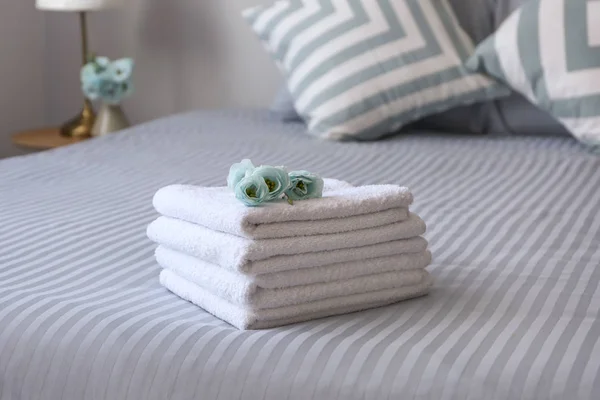 Stack of clean towels on bed — Stock Photo, Image