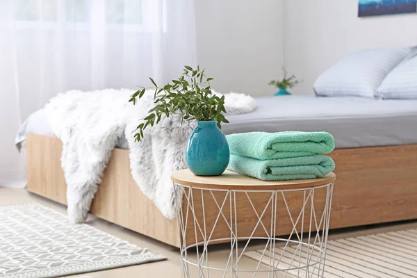 Stack of clean towels on table in bedroom — Stock Photo, Image