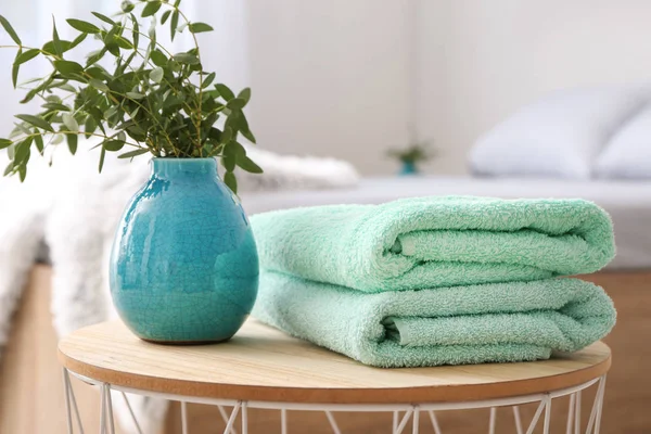 Pilha de toalhas limpas na mesa no quarto — Fotografia de Stock