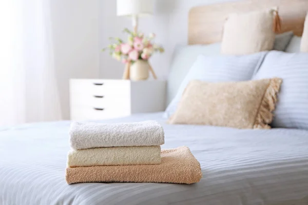 Stack of clean towels on bed — Stock Photo, Image