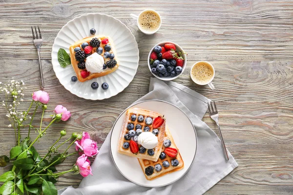Tasty sweet waffles with coffee on wooden table — Stock Photo, Image