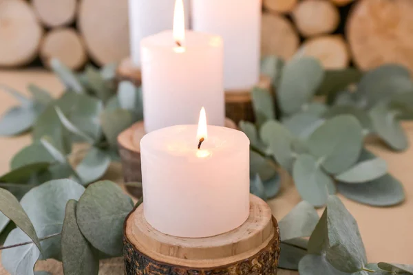 Belle candele ardenti e rami di eucalipto sul tavolo, primo piano — Foto Stock