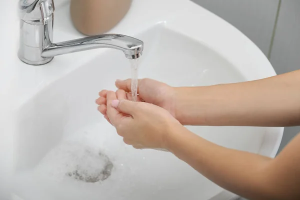 Junge Frau beim Händewaschen im Waschbecken — Stockfoto