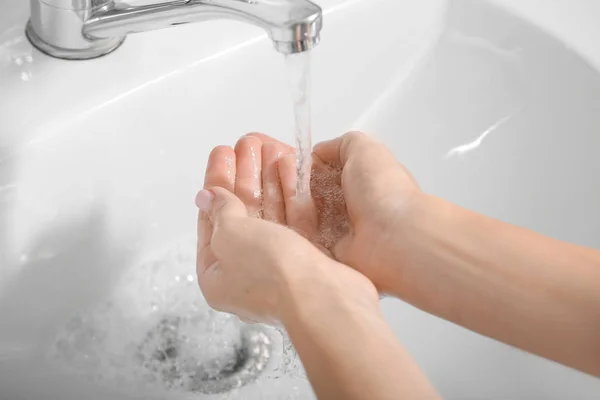 Ung kvinna handtvätt i diskhon — Stockfoto