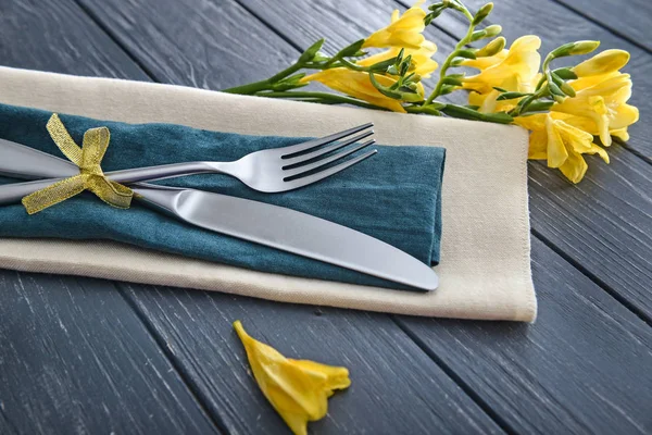 Cutlery, napkin and flowers on wooden background, closeup — Stock Photo, Image