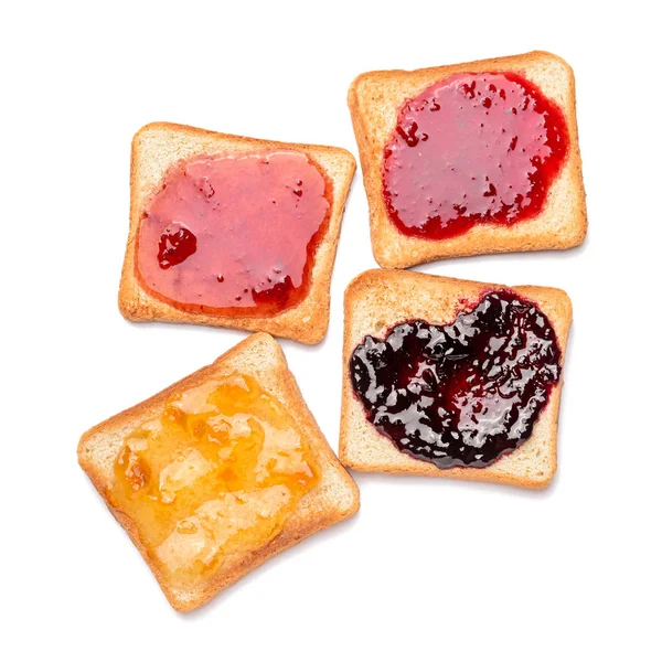 Tasty toasted bread with different jams on white background — Stock Photo, Image
