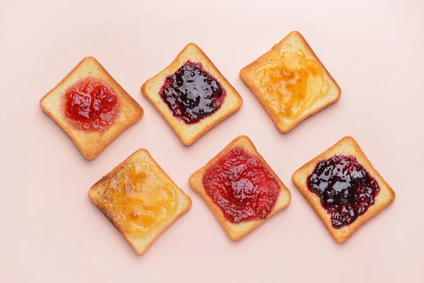 Pão torrado saboroso com diferentes compotas no fundo claro — Fotografia de Stock