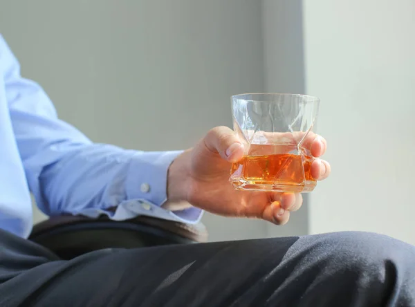 Uomo con bicchiere di whisky a casa — Foto Stock