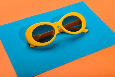 Şık güneş gözlüğü ve renkli arka plan üzerinde kağıt levha