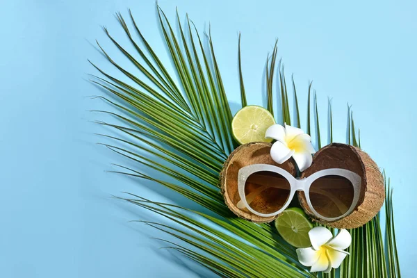 Stylische Sonnenbrille, Kokosnuss, Blumen und Palmblatt auf farbigem Hintergrund — Stockfoto