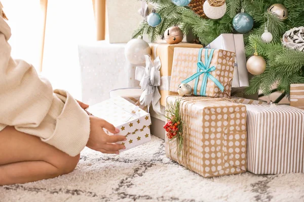 Woman putting gift boxes under Christmas tree — Stock Photo, Image