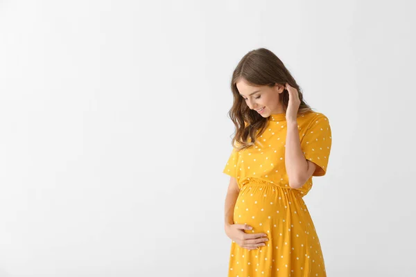 Mooie zwangere vrouw op lichte achtergrond — Stockfoto