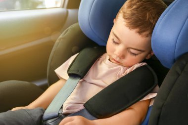 Uyuyan erkek bebek oto koltuğunda büküldü