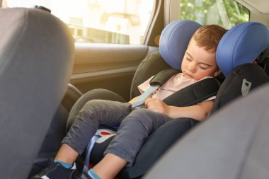 Uyuyan erkek bebek oto koltuğunda büküldü