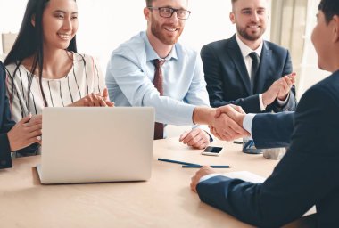 İnsan kaynakları yöneticisi başarılı bir röportajdan sonra başvuranla tokalaşıyor