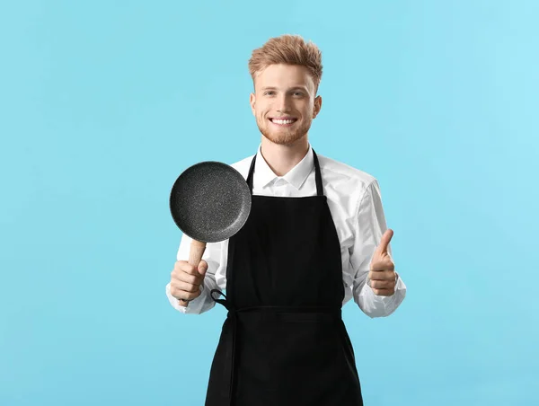 Handsome male chef with frying pan showing thumb-up on color background — Stock Photo, Image