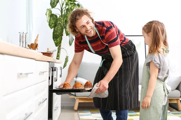 Young man and his little daughter baking tasty muffins at home — Stock Photo, Image