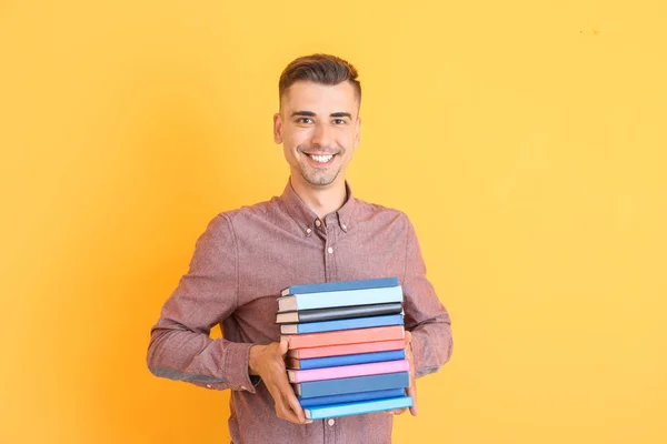 Handsome male teacher with books on color background — Stock Photo, Image