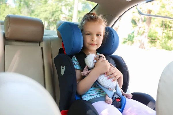 Menina fivela no assento de segurança do carro — Fotografia de Stock
