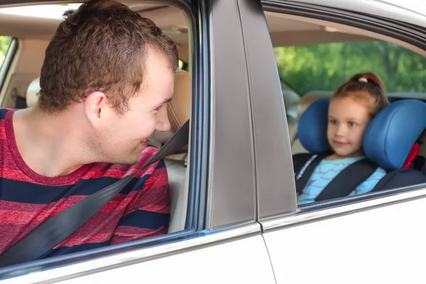 Homem dirigindo carro com sua filha fivela no assento de segurança — Fotografia de Stock