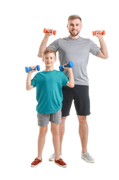 Retrato de pai e filho treinando com halteres em fundo branco — Fotografia de Stock