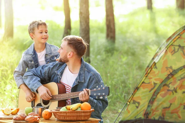Padre y su hijito con guitarra haciendo un picnic en el bosque —  Fotos de Stock