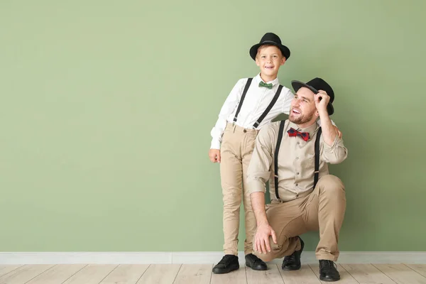 Portrait of fashionable father and son near color wall — Stock Photo, Image