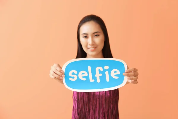 Női ázsiai blogger kezében papírt a szöveg Selfie színes háttér — Stock Fotó