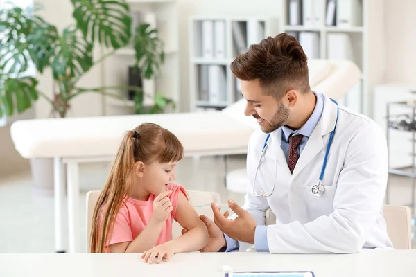 Læge vaccinerer lille pige på klinikken - Stock-foto