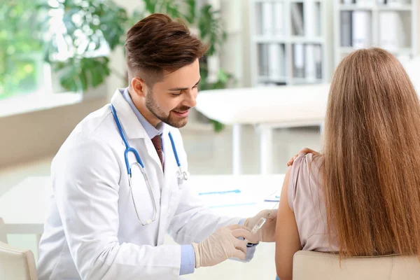 Doktor vaccinerande ung kvinna i kliniken — Stockfoto