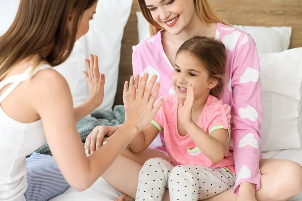 Happy lesbian couple with little daughter in bedroom — Stock Photo, Image