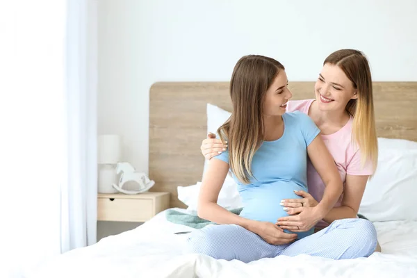 Happy pregnant lesbian couple in bedroom — Stock Photo, Image