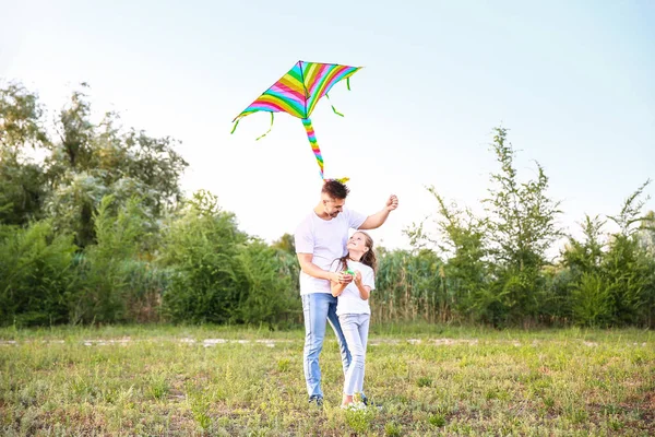 Junger Mann mit kleiner Tochter fliegt Drachen im Freien — Stockfoto