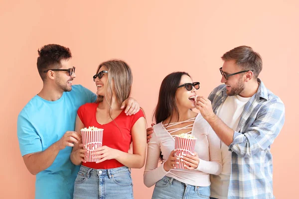 Amici mangiare popcorn su sfondo di colore — Foto Stock