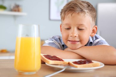 Komik küçük çocuk mutfakta reçel ile lezzetli tost yeme