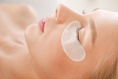 Güzellik salonunda kirpik laminasyon prosedürü geçiren genç kadın, closeup