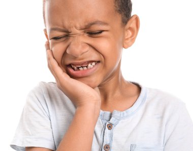 Little African-American boy suffering from toothache against white background clipart
