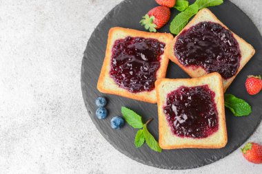 Gri masada lezzetli tost ekmeği ve dut reçeli ile arduvaz tabağı