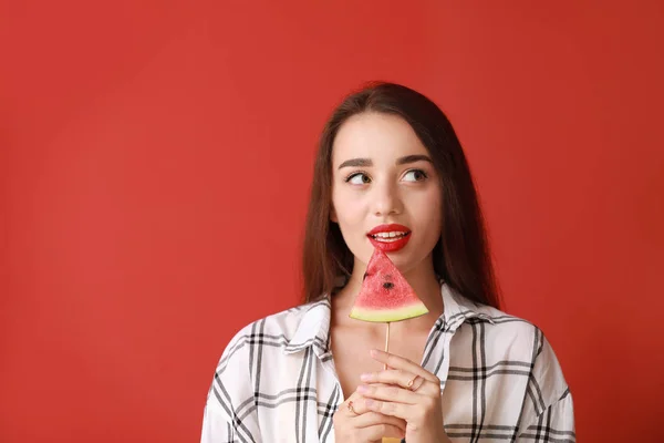 Belle jeune femme avec tranche de pastèque fraîche sur fond de couleur — Photo